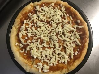 秘制芝心卷边披萨,撒上一层马苏里拉芝士粒。