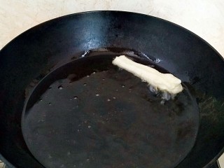 早餐油条,玉米油烧7成热，放入一块面试炸一次，面团立马漂浮起来，油温就够了。