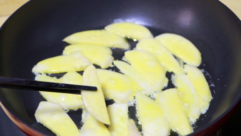 蛋黄煎杏鲍菇,将杏鲍菇片撇去多余的蛋糊后放入锅中