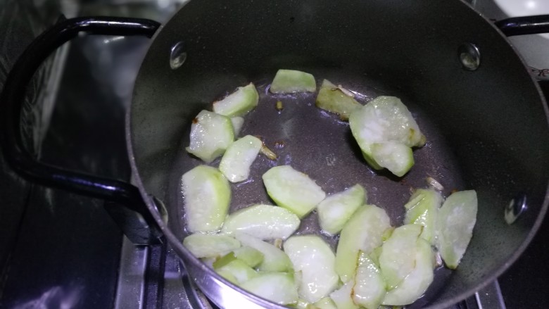 丝瓜豆腐蛤蜊汤,上锅入油热，放入丝瓜炒软加入少许热水，记得是加入热水，炒菜最忌讳的是热腾腾的锅里加冷水