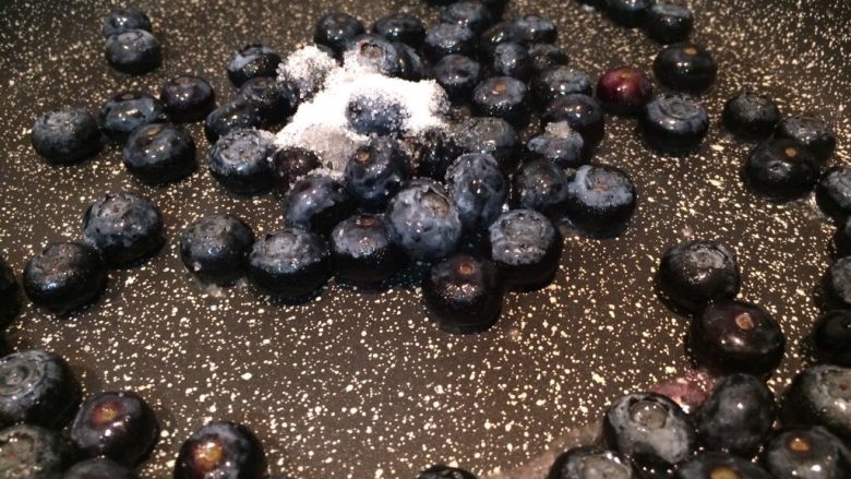 双莓慕斯蛋糕,清洗干净的蓝莓放入不粘锅中，加入10克细砂糖，用中小火煮。