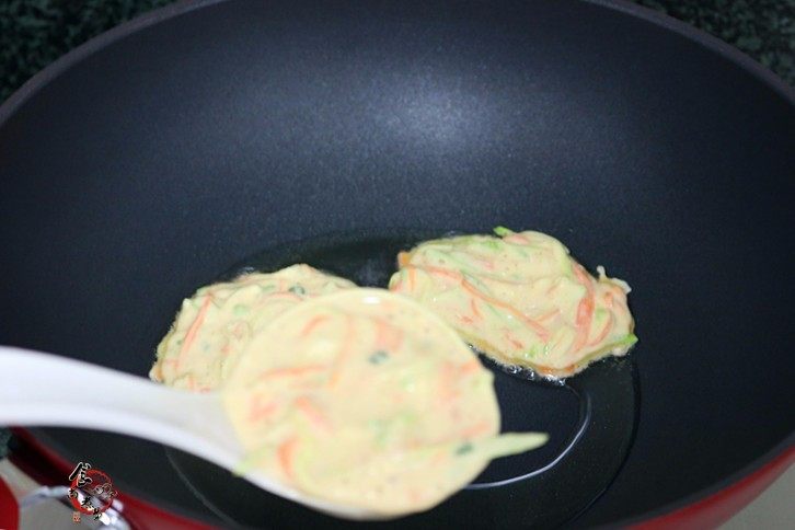 西葫芦鸡蛋煎饼,用勺子舀起面糊，放入煎锅中