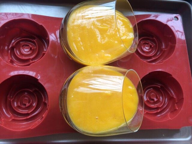 芒果酸奶冻,把杯子斜放在模具里或其它的物体托中，倒入芒果泥，放入冰箱冷藏2-3小时定型。
