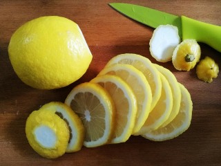 柠檬蜜,去掉头尾，用刀切成薄片（日常处理材料时如果是用木制砧板需首先把砧板浸湿，以防食材的颜色或者味道吸入砧板），这里必须记得擦干砧板表面的水再切柠檬