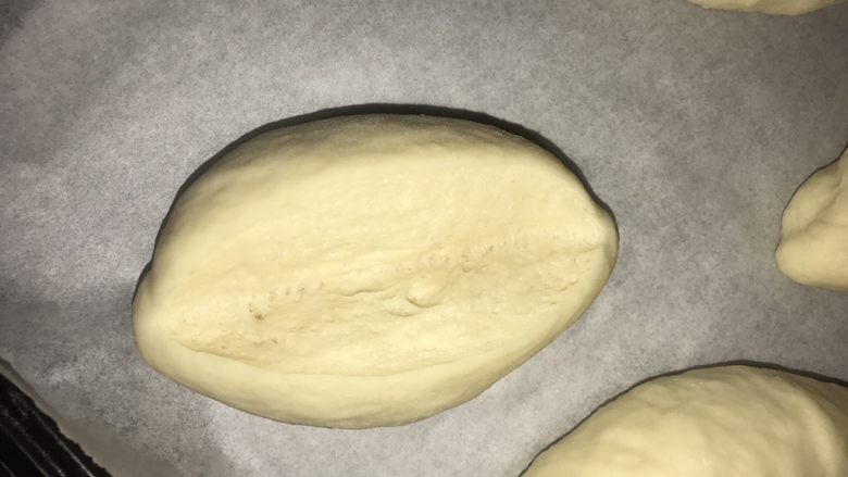 免出膜香肠包,整形成橄榄形，再次发酵至1倍大，纵向中间割开