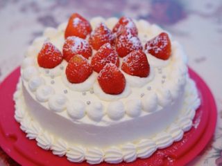 生日蛋糕—草莓奶油蛋糕,最后用裱花嘴裱花，放上剩下的草莓，撒上装饰糖和糖霜