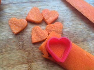 胡萝卜香葱爱心饼干,然后胡萝卜洗干净去皮，再切成薄度一直的片状，然后用小小的爱心模具按压一下就出了爱心了，我这个爱心模具跟拇指大小差不多。