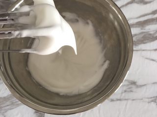 Fluff棉花糖之焦糖舒芙蕾,蛋白霜变细腻时加入第二次白砂糖。
蛋白霜出现纹路时加入剩下的白砂糖。
期间不要停止打蛋器，打到出现小弯勾的湿性发泡状态即可。