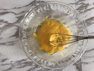 Fluff棉花糖之焦糖舒芙蕾,先来制作卡仕达酱。
蛋黄中加入细砂糖，用手动打蛋器搅打均匀，筛入低筋面粉，用手动打蛋器搅打均匀，周围不均匀的面粉用刮刀刮下来，搅拌到无粉的状态。