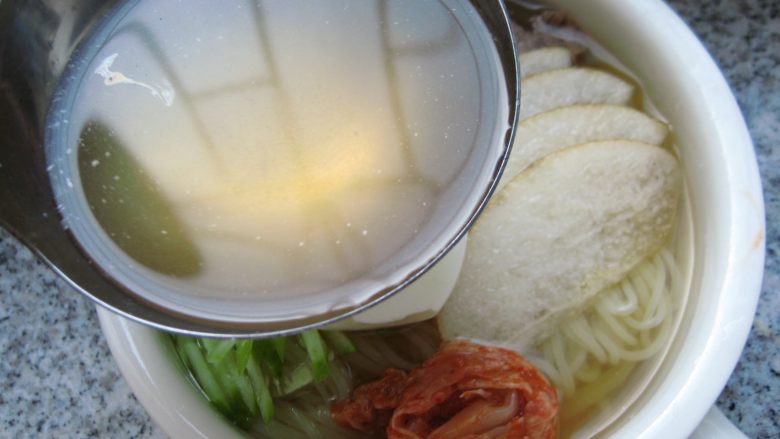 鲜族冷面:冰凉爽口.夏之美味,倒入冰镇好的冷面汤，再撒上香菜末和辣椒油，一碗味道纯正的韩式牛肉汤冷面就做好了。
