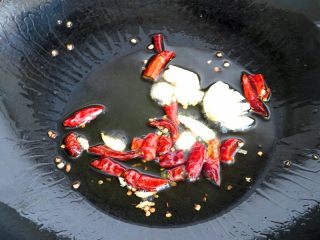 开胃酸辣西瓜皮,热锅注入油烧至6分热，下入蒜和红干椒爆香