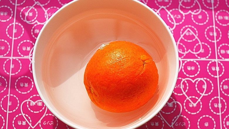 鲜橙磅蛋糕,碗里装凉开水，放入少许小苏打粉搅匀，撒上少许盐在橙子上，用力抹，务必要将表皮的蜡洗去，然后放水中静置一会儿，再冲干净
