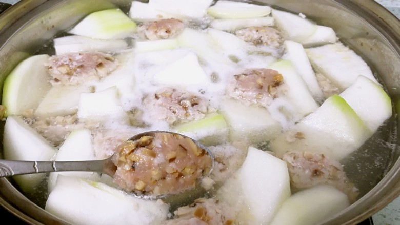 香菇肉滑蒲瓜汤,收小火。用勺子舀起肉泥，在碗边压一下，整一整形，再滑入汤中。