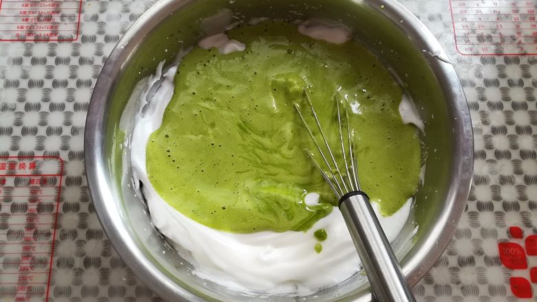 低糖菠菜戚风,把蛋黄糊倒回装有蛋白的盆里，继续同样手法翻拌均匀
