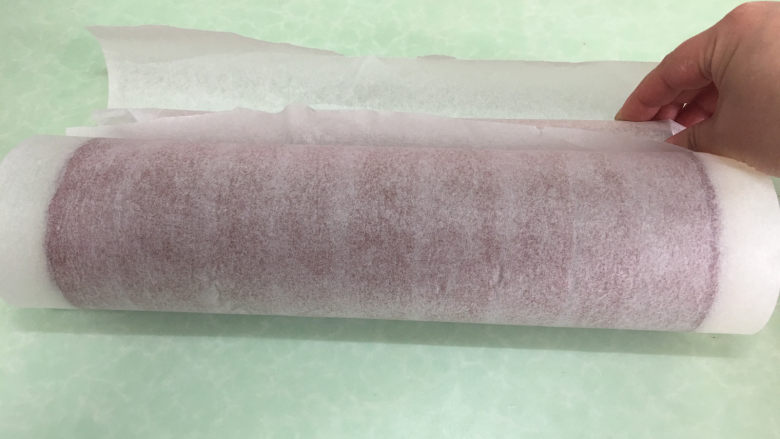 红丝绒旋风蛋糕卷,用擀面杖卷起蛋糕后放冰箱冷藏定型。