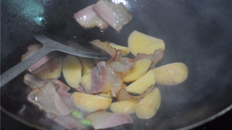 懒人餐，一锅出——腊肉排骨饭,倒入土豆块和排骨，稍微翻炒几下