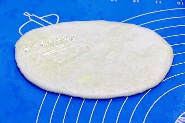 心形椰蓉面包,把包好椰蓉馅的面团擀开成椭圆形。温柔点哈，不要擀的露陷啊。