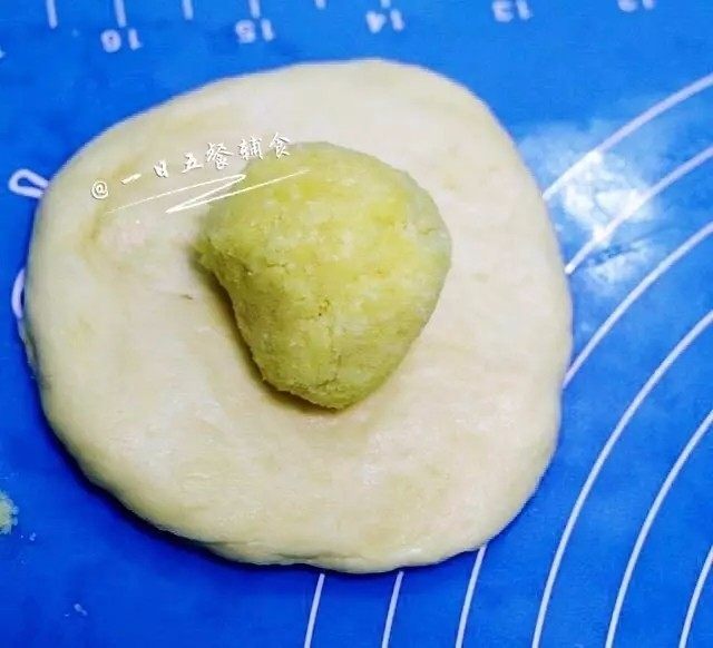 心形椰蓉面包,取一份面团擀开成圆形，包入椰蓉馅，收口处捏紧