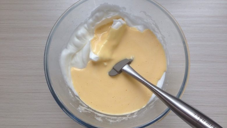 超柔软的棉花蛋糕,用刮刀翻拌均匀，然后倒回剩余的蛋白霜里，用同样的手法翻拌均匀。