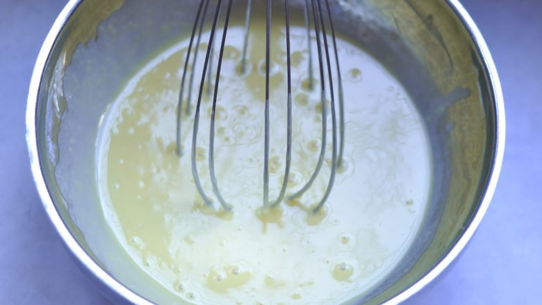 日式棉花蛋糕,将油面糊倒入蛋黄液中搅匀，搅好的蛋黄糊是可以流动的。