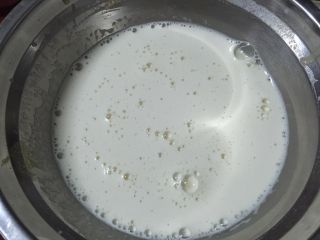 北海道戚风,把1/3煮沸的牛奶缓缓倒入蛋黄面糊里，边倒边不停的搅拌；把搅拌好的蛋黄面糊全部倒回牛奶锅里，并轻轻拌匀