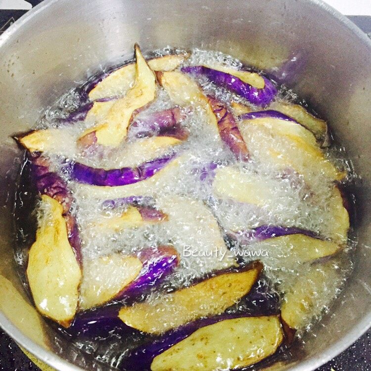 娃娃家常菜—简单易做的鱼香茄子,油热后，下茄子炸（油温要高，放入的茄子会迅速定型）定型后捞出，沥干油份备用。