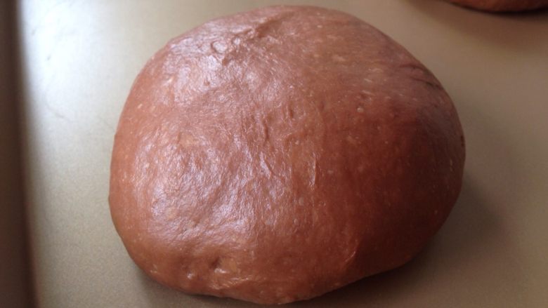 可可麻薯软欧包,圆形的收口朝下，放在不粘烤盘上