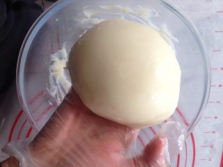 可可麻薯软欧包,趁热加入黄油揉均匀，包上保鲜膜，放入冰箱冷藏备用。