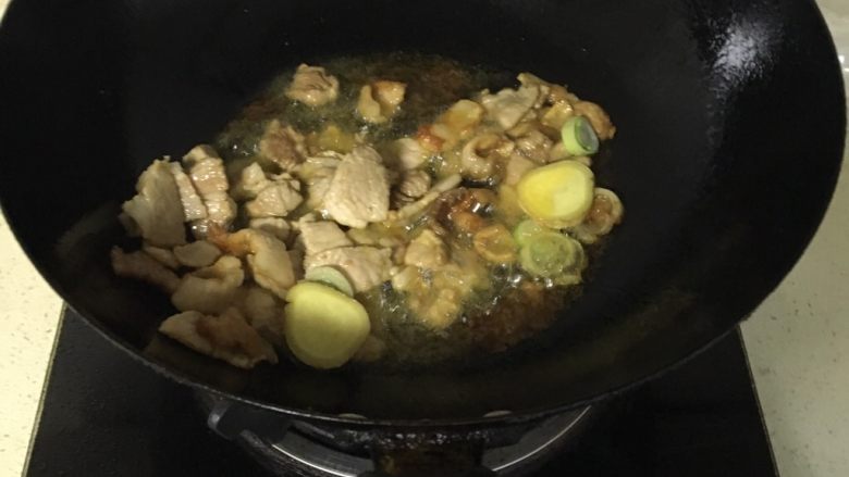 猪肉炖豆角,锅里放油烧热炒肉，肉炒变色加入葱花姜