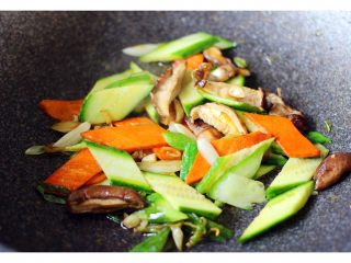 扇贝海鲜杂蔬羹,胡萝卜煸炒软以后、加入黄瓜片和花菇片继续翻炒