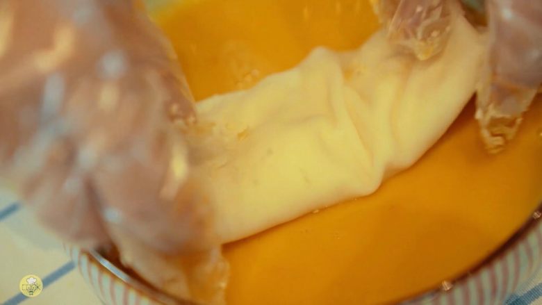 酥皮流心炸牛奶，岭南风味,把牛奶条每一面均匀沾上蛋液