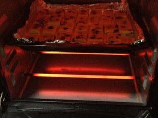 葡萄奶酥,把烤盘放入预热好的烤箱，中层上下火180度，烤10分钟左右，直到表面金黄色。
