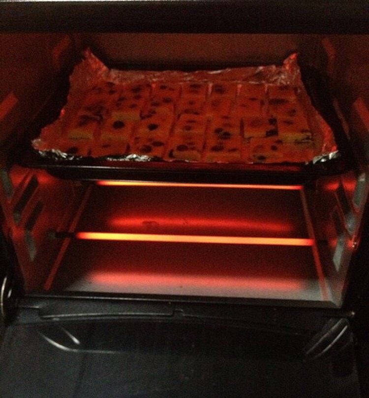 葡萄奶酥,把烤盘放入预热好的烤箱，中层上下火180度，烤10分钟左右，直到表面金黄色。