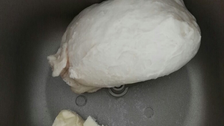 小乌龟面包#面团的发酵之旅#,放入面包机搅拌至光滑，加入黄油和盐继续搅拌（用的后盐后油法）