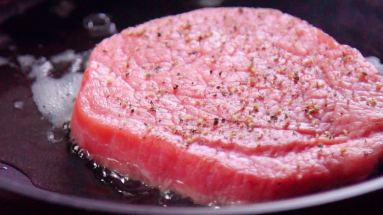 泰国牛肉色拉,将腌制好的牛肉放入锅中煎至三分熟。