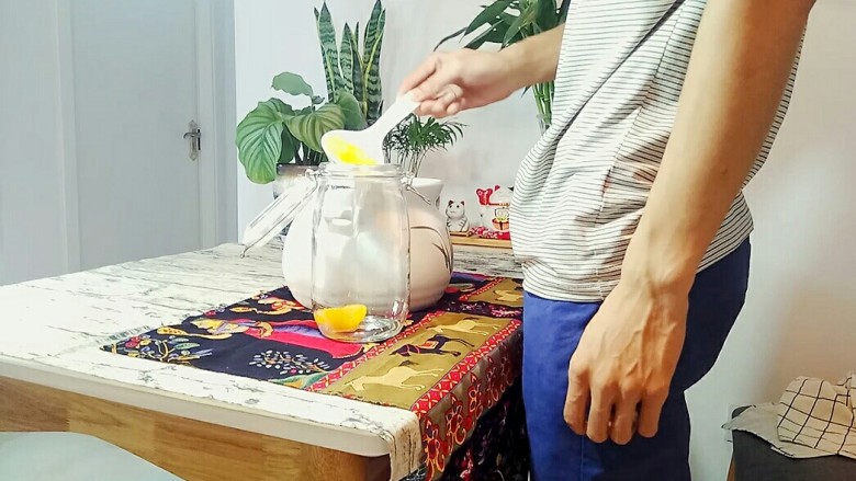 自制桃罐头,放凉后，用勺子把油桃捞到密封罐中，最后把锅里的糖水也倒进去。