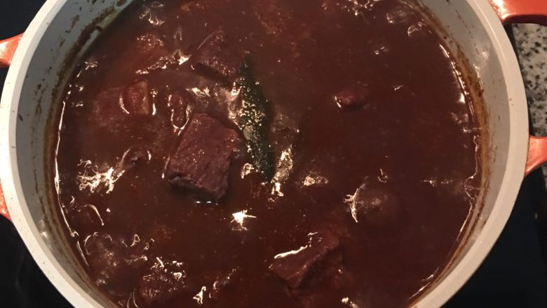 紅酒燉牛肉（一鍋到底）,一小時後，先撈出蒜頭，用濾網將蒜肉壓成泥，除去蒜皮，將蒜泥混入湯汁中；試味道用鹽調整後，