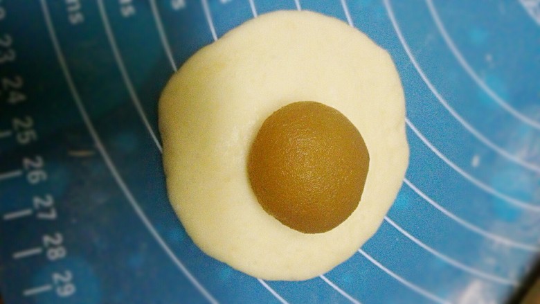蘑菇包+#面团发酵之旅#,取一个剂子用擀面杖擀成这样饼状，不能太薄，放上莲蓉馅
