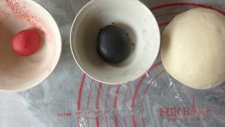 企鹅馒头,取30克面团加入适量的竹炭粉，和成黑色面团。取十克面团加入红曲粉，和成红色面团。