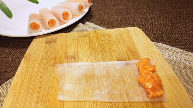 白玉鲈鱼卷,把鱼肉泥放在萝卜皮上边的一端。
