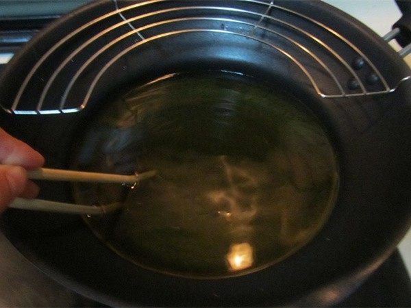 酥脆麻花,将锅中油烧热， 用筷子不停的搅动油锅， 这样油的温度会上升的快一些；
