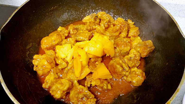 芒果酸甜排骨,关火，倒入排骨和芒果，翻炒几下，让排骨和芒果均匀挂上酱汁。