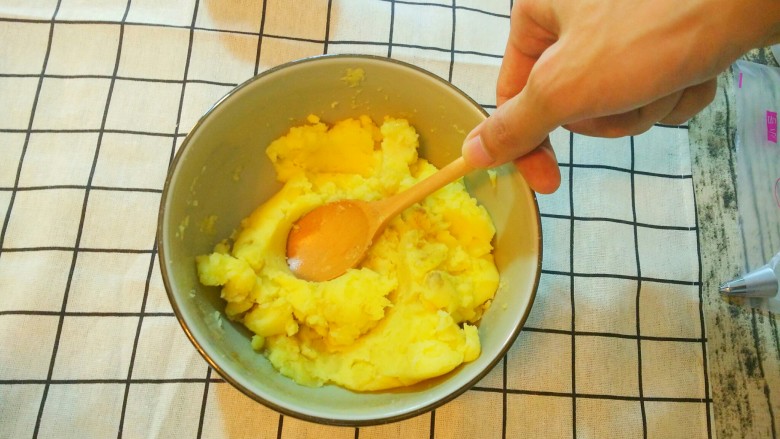 烤土豆泥,拿一把勺子，吧土豆泥和调料充分搅拌均匀。