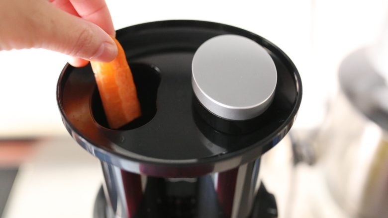 双色菜汁花卷：把维生素揉进面团里,将胡萝卜条放入原汁机中。