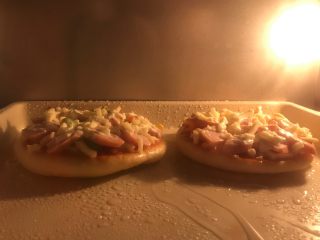迷你香肠披萨,烤箱预热上火180度下火160度5分钟，放入披萨烘烤9分钟至马苏里拉芝士溶化即可，没有上下火分开设温的可以都选择180度，7分钟左右即可。