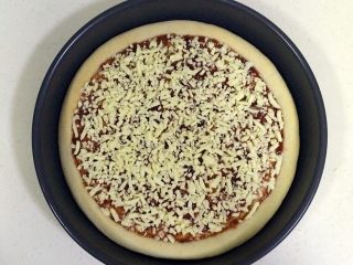 培根口蘑田园披萨,撒上一半的马苏里拉奶酪。