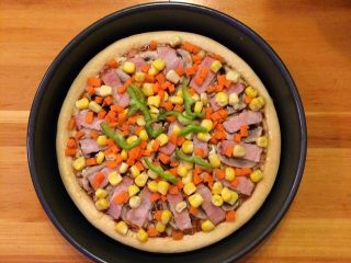培根口蘑田园披萨,然后取出披萨，继续撒上玉米粒和胡萝卜粒以及青椒丝。