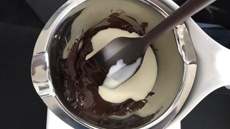巧克力淋面蛋糕,巧克力全部融化后，加入30克淡奶油。
可以一点点加入，观察甘纳许状态。
全程隔热水搅拌均匀。