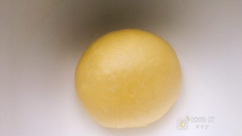 软软软软软的南瓜小餐包（淡奶油版）,取出面团，再次揉成团。
盖上保鲜膜室温发酵一小时。