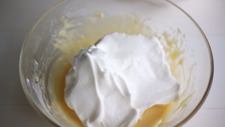 丑萌莎莉奶油蛋糕,将1/2的蛋白霜加入到蛋黄糊中，翻拌均匀